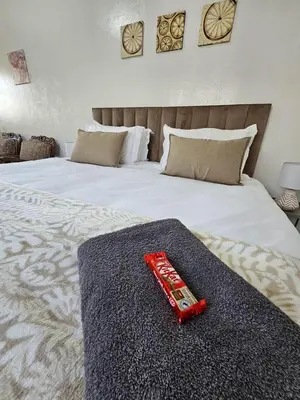 a red remote control sitting on top of a bed at De Villa Guesthouse in Middelburg