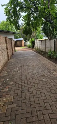 a brick driveway in a yard with a fence at De Villa Guesthouse in Middelburg