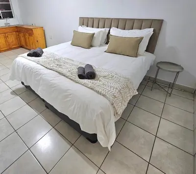 a bedroom with a large bed with two slippers on it at De Villa Guesthouse in Middelburg