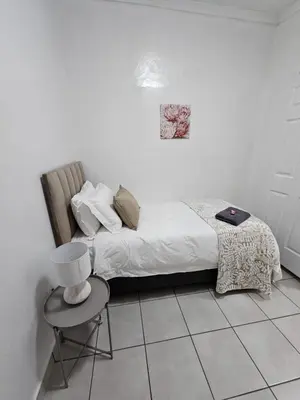 a bedroom with a bed with a chair and a table at De Villa Guesthouse in Middelburg