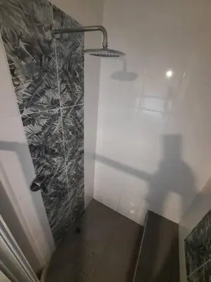 a bathroom with a shower with a glass wall at Nel's Studio in Benoni