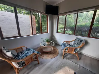 a room with two chairs and a table and windows at Nel's Studio in Benoni