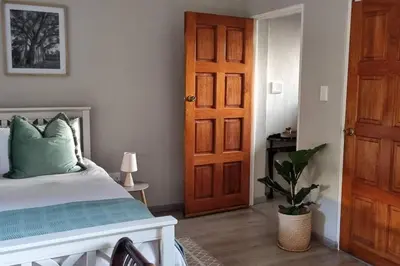 a bedroom with a bed and a wooden door at Nel's Studio in Benoni
