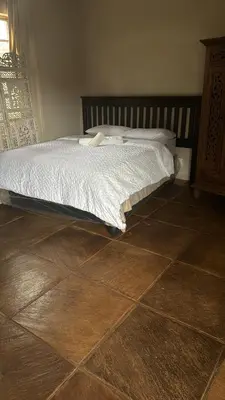 a bed in a bedroom with a wooden floor at Joes Country lodge in White River