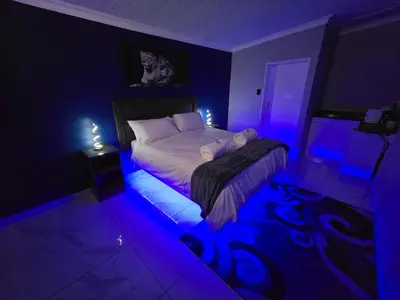 a bedroom with a bed with purple lights on it at Impala Palms Guesthouse in Modimolle