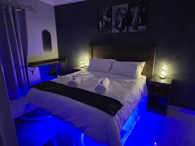 a bedroom with a bed with blue lights on it at Impala Palms Guesthouse in Modimolle