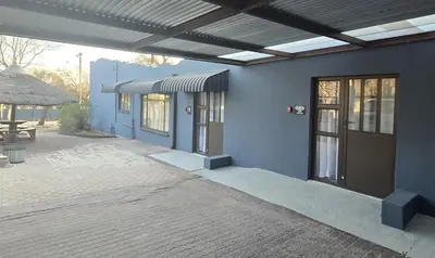 a blue building with a door and a patio at Impala Palms Guesthouse in Modimolle