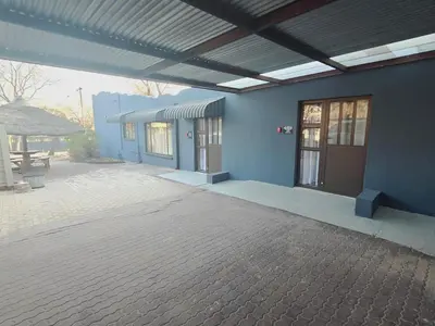 a blue building with a door and a patio at Impala Palms Guesthouse in Modimolle