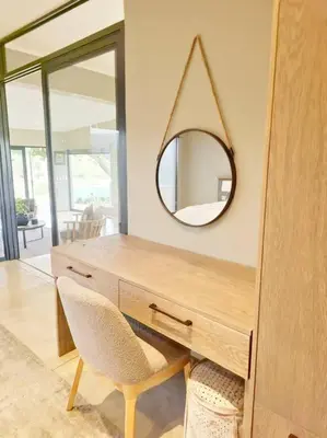 a wooden desk with a mirror and a chair at Simbini Sunset Cottage in Malelane