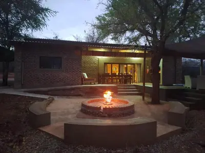 a fire pit in a yard in front of a house at The Hedgehog at Marloth Park in Marloth Park