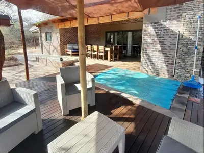 a patio with a swimming pool on a wooden deck at The Hedgehog at Marloth Park in Marloth Park