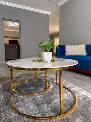 a coffee table in a living room with a blue couch at AndriMat Villa Harties in Hartbeespoort