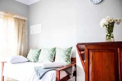 a bedroom with a bed with green and white pillows at Earthy Inn in Pretoria