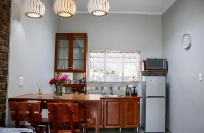 a kitchen with a table and a refrigerator at Earthy Inn in Pretoria