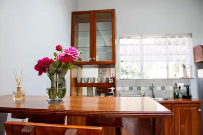 a vase of flowers on a table in a kitchen at Earthy Inn in Pretoria