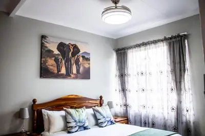 a bedroom with a bed and a window at Earthy Inn in Pretoria