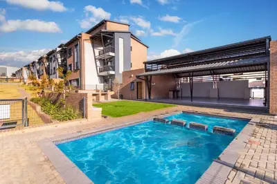 a swimming pool in front of a building at The Ridge View in Midrand