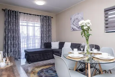 a living room with a table and a couch at The Ridge View in Midrand
