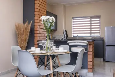 a kitchen and dining room with a table and chairs at The Ridge View in Midrand
