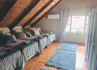 two beds in a room with blue rugs at Vivo Per Lei - Marloth Park in Marloth Park