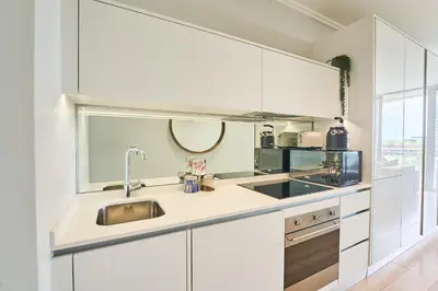 a white kitchen with a sink and a microwave at 8's at Ellipse Waterfall in Midrand