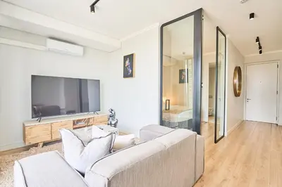 a living room with a couch and a flat screen tv at 8's at Ellipse Waterfall in Midrand