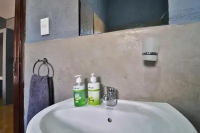 a bathroom sink with two bottles of soap on it at Ilanga Kruger Lodge in Marloth Park