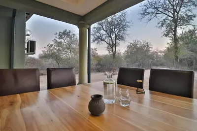 a wooden table with a vase on top of it at Ilanga Kruger Lodge in Marloth Park