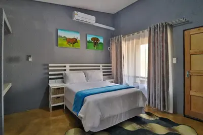 a bedroom with a bed and a window at Ilanga Kruger Lodge in Marloth Park