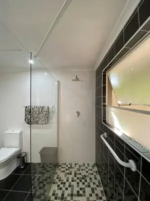 a bathroom with a shower and a sink and a toilet at Cottage on Keurboom in Midrand