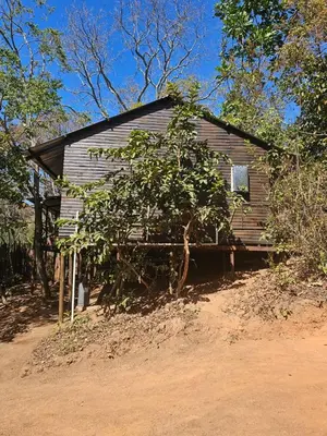 an old wooden house in the middle of a field at Whispering Creek Mountain Lodge in Magoebaskloof