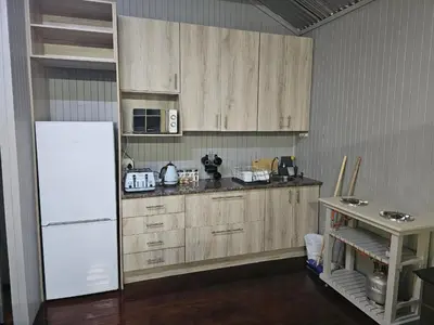 a kitchen with wooden cabinets and a white refrigerator at Whispering Creek Mountain Lodge in Magoebaskloof