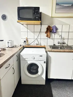 a kitchen with a washing machine and a sink at Serene Stays Elarduspark in Pretoria