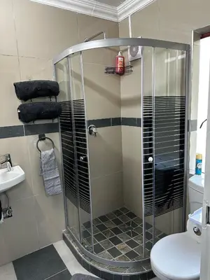 a shower with a glass door in a bathroom at Serene Stays Elarduspark in Pretoria