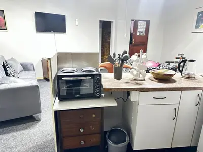 a kitchen with a counter with a microwave on a counter at Serene Stays Elarduspark in Pretoria