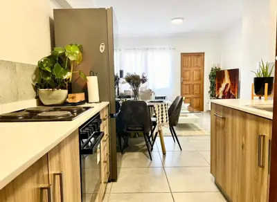 a kitchen with a stove and a dining room at Suburban Suites at The Reeds in Centurion