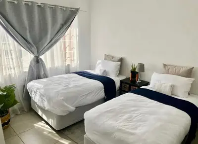 a bedroom with two beds and a window at Suburban Suites at The Reeds in Centurion