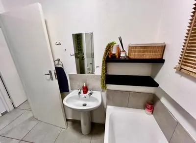 a white bathroom with a sink and a toilet at Suburban Suites at The Reeds in Centurion