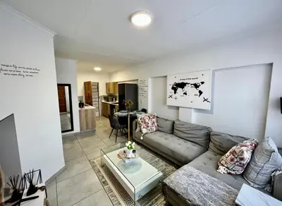 a living room with a couch and a table at Suburban Suites at The Reeds in Centurion