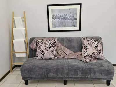 a gray couch with two pillows on it in a room at Marilyn's Cottage in White River