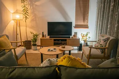 a living room with a couch and a tv at Marilyn's Cottage in White River