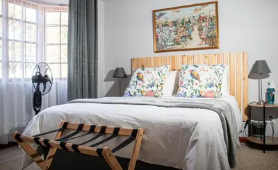 a bedroom with a large bed with a wooden headboard at Marilyn's Cottage in White River