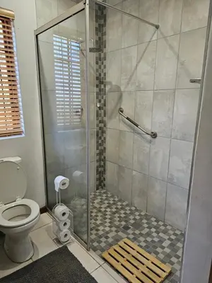 a shower stall in a bathroom with a toilet at Marilyn's Cottage in White River