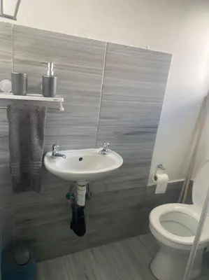 a bathroom with a sink and a toilet at The Royal Kyota in Sandton