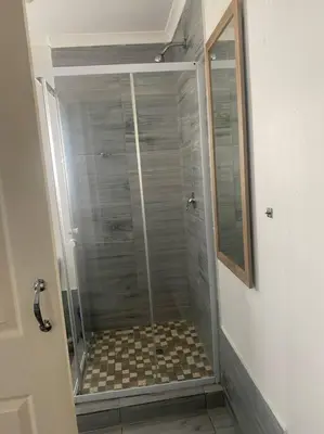 a shower with a glass door in a bathroom at The Royal Kyota in Sandton