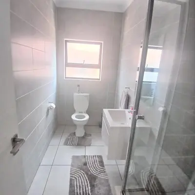 a bathroom with a toilet and a sink and a shower at The Blyde 2-Bed Luxe Apartment in Pretoria