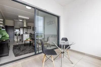 a dining room with a glass table and chairs at Fredas Place 92 On New in Midrand