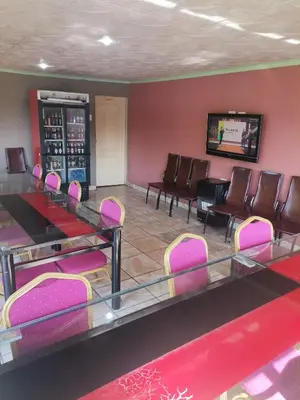 a waiting room with pink chairs and a table at Delapaix Guest lodge in Kempton Park