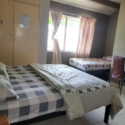 a small bedroom with a bed and a window at Delapaix Guest lodge in Kempton Park
