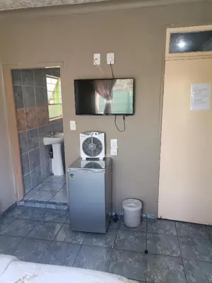 a bathroom with a sink and a tv on the wall at Delapaix Guest lodge in Kempton Park